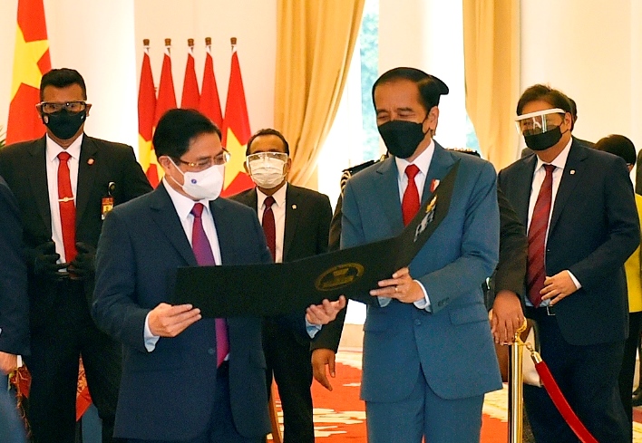 Tổng thống Indonesia Joko Widodo thân tặng Thủ tướng Phạm Minh Chính tấm hình kỷ niệm cuộc gặp đầu tiên trên cương vị Thủ tướng - Ảnh: VGP/Nhật Bắc              